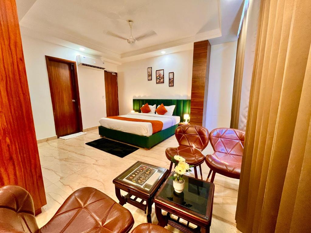 a hotel room with a bed and some chairs at Hotel La Casa Amritsar Near ISBT & Golden Temple in Amritsar