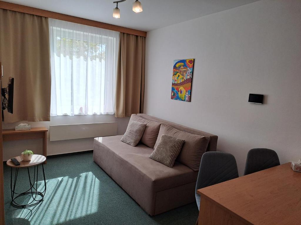 a living room with a couch and a table at Apartmán PalacKY in Kyjov