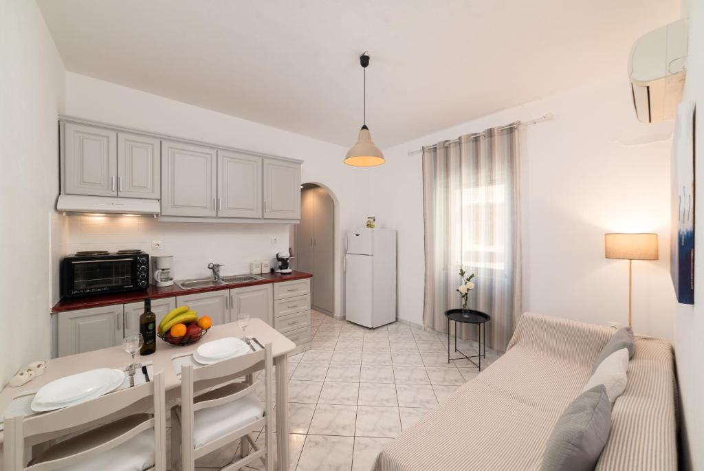 een keuken en een woonkamer met een tafel bij Evangelia cozy apartment in Agios Nikolaos