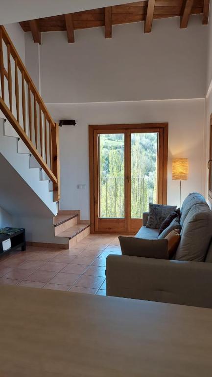 a living room with a couch and a staircase at Apartament Rural Burg in Burg