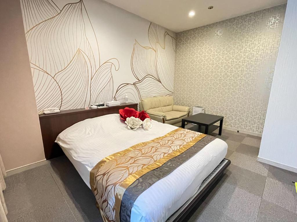 - une chambre avec un lit orné d'une fleur rouge dans l'établissement ホテル レディ, à Kōtōdaitōri