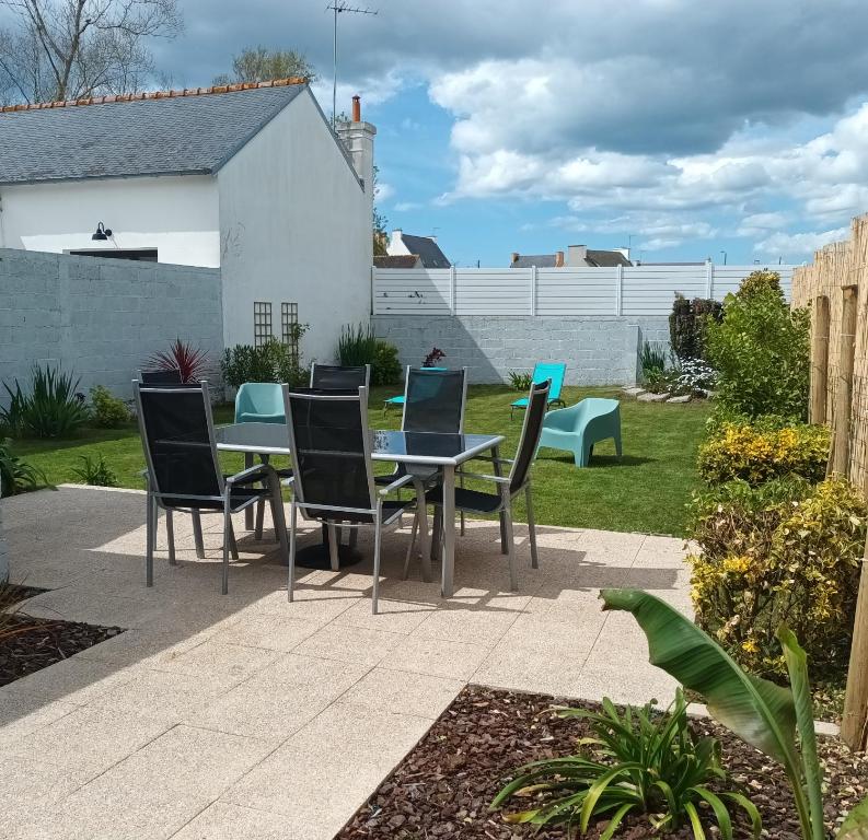 eine Terrasse mit einem Tisch und Stühlen im Hof in der Unterkunft L'Escale Bretonne 6 personnes, proche mer et centre ville, jardin privé et clos in Le Guilvinec