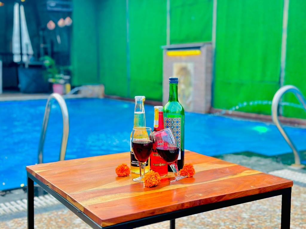 a table with two glasses of wine and a bottle at Hotel The Casa Hamilton, City Centre Amritsar in Amritsar