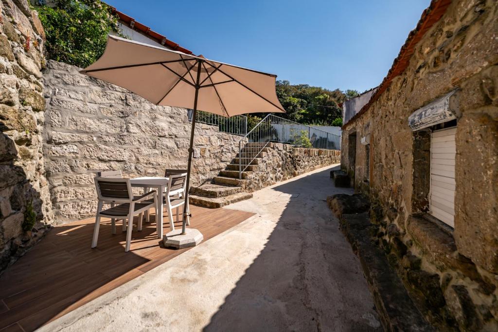 een tafel en stoel met een parasol op een veranda bij Douro View Charming Apartment Duplex in Valbom