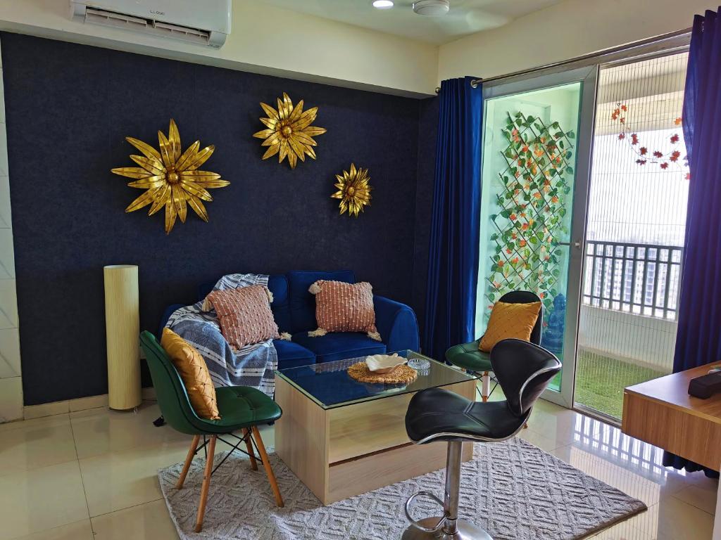 a living room with a blue couch and chairs at Sandal suite by Mulberry Homestays in Noida