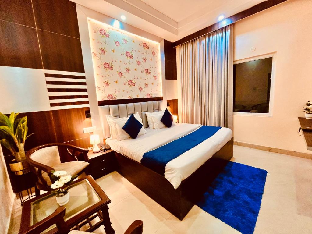 a hotel room with a bed and a chair and a table at Hamilton Hotel & Resort, Near Golden Temple Parking Amritsar in Amritsar