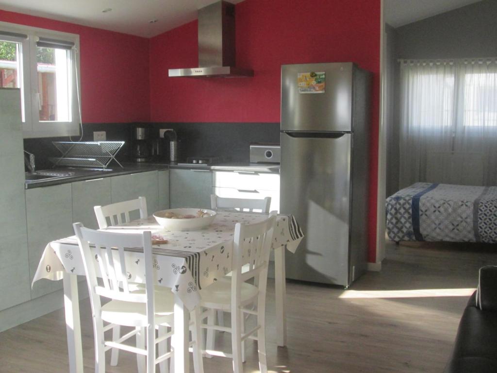 eine Küche mit einem Tisch mit Stühlen und einem Kühlschrank in der Unterkunft Petite maison au calme in Telgruc-sur-Mer