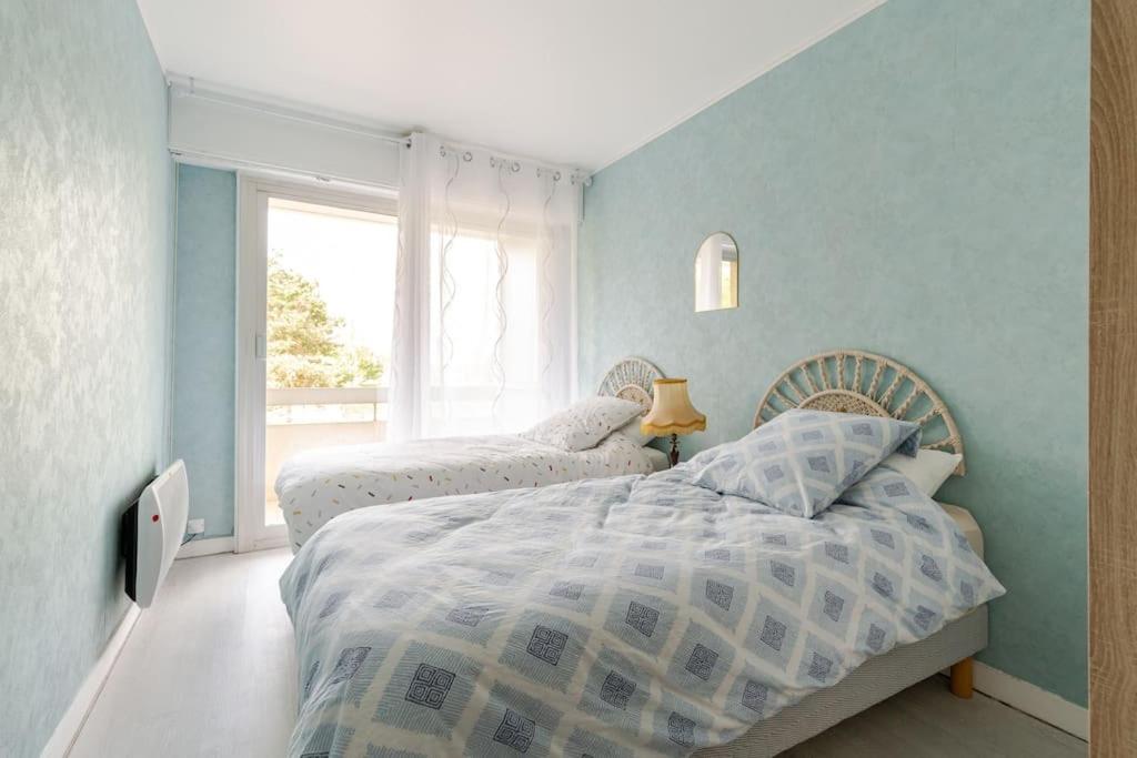 1 Schlafzimmer mit 2 Betten und einem Fenster in der Unterkunft Appartement Lumineux avec parking privé à proximité de la Plage Benoît de La Baule in La Baule