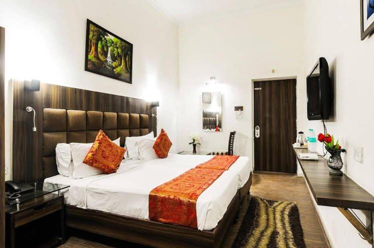 a bedroom with a large bed and a television at Hotel Urban Zip in Agra