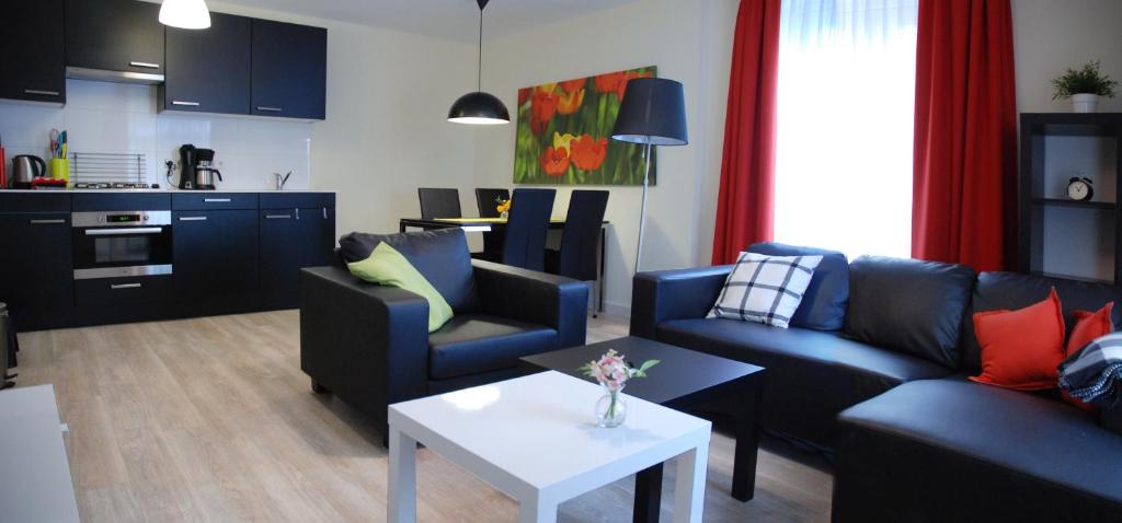 a living room with two couches and a table at Huis van Egmond aan Zee in Egmond aan Zee