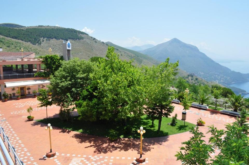a view of a park with trees and a building at Residence Pianeta Maratea in Maratea
