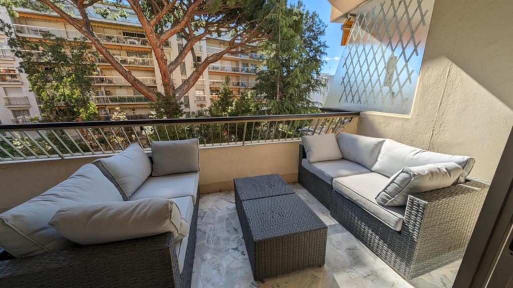 - un balcon avec deux canapés et une table dans l'établissement LACOUR7 Palmes dProperties, à Cannes