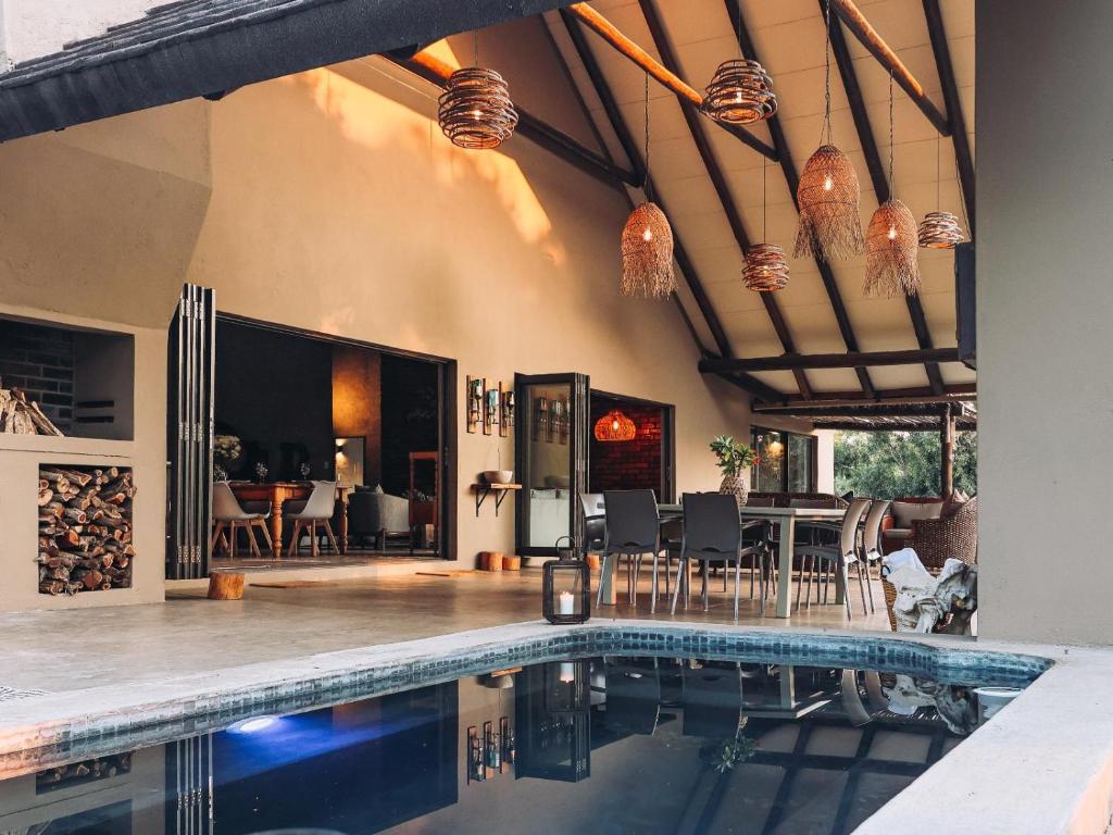 a house with a swimming pool and a dining room at Rhino's Rest Luxury Villa in Hoedspruit
