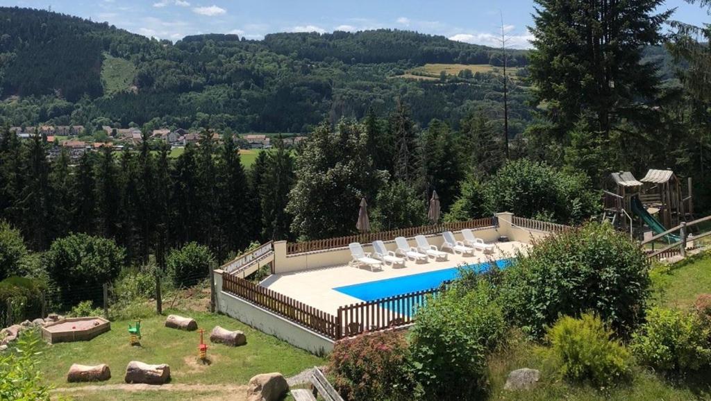a swimming pool with lounge chairs at Camping du Château in Granges-sur-Vologne