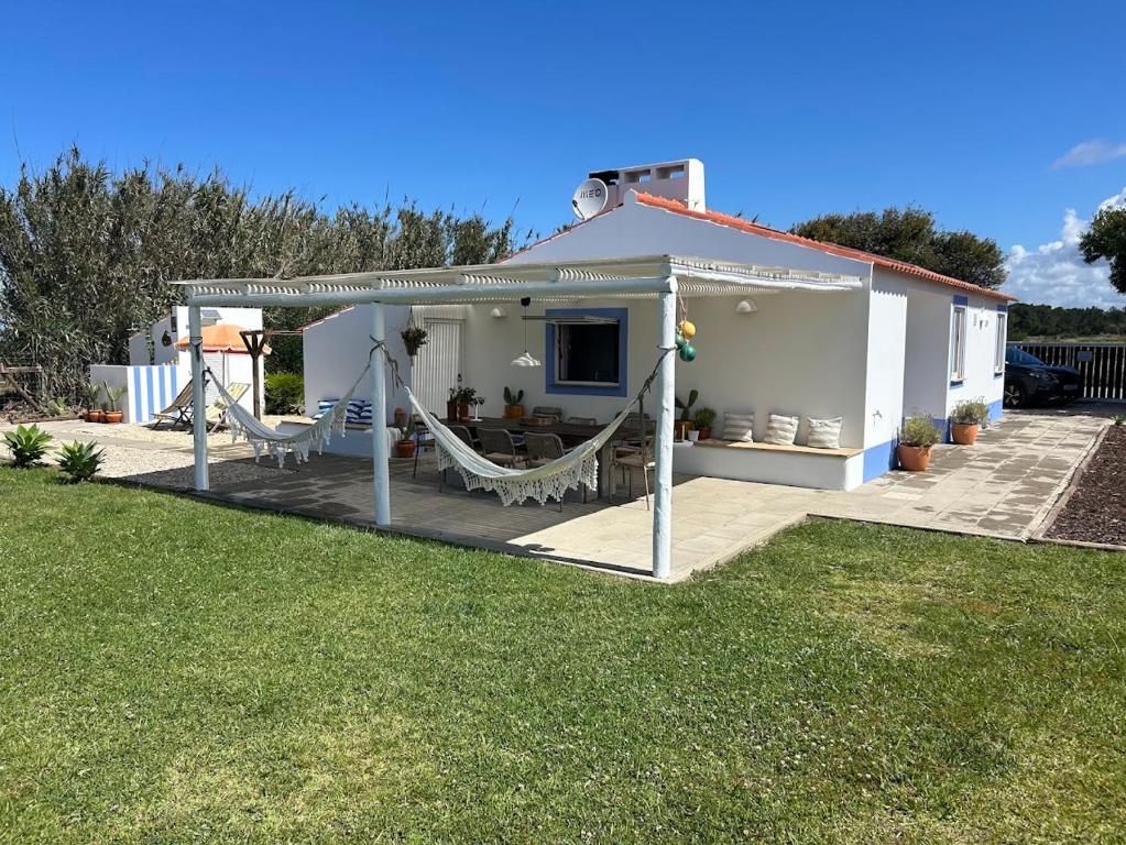 ein weißes Haus mit einer Hängematte im Hof in der Unterkunft Casa da Maria • Natural Côte • Aljezur in Maria Vinagre