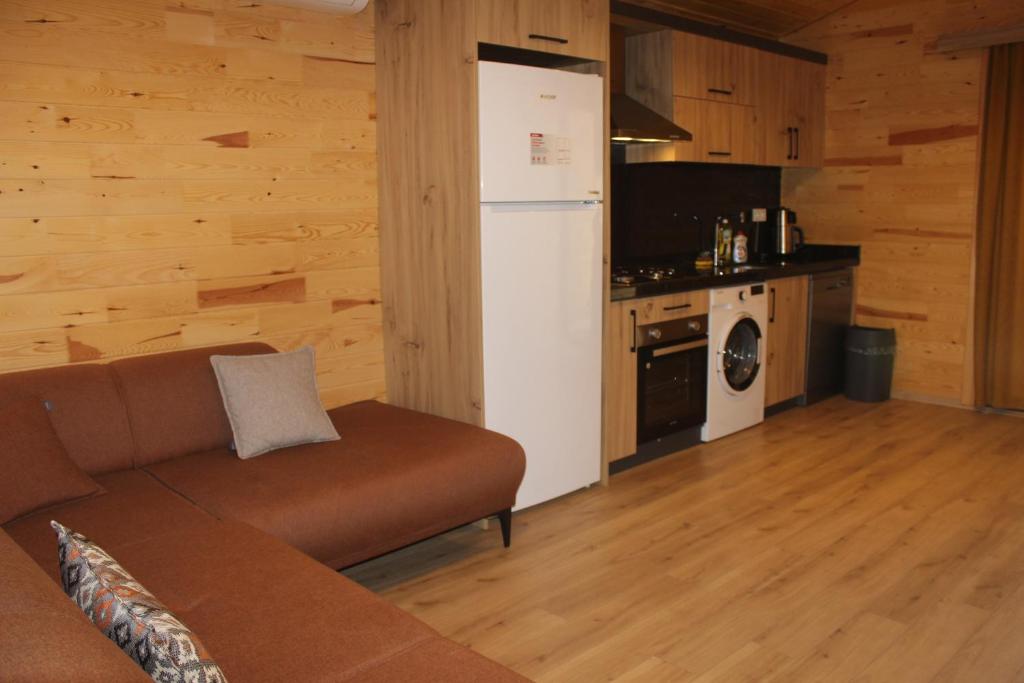 a living room with a couch and a kitchen at Çıralı Villa's in Kemer