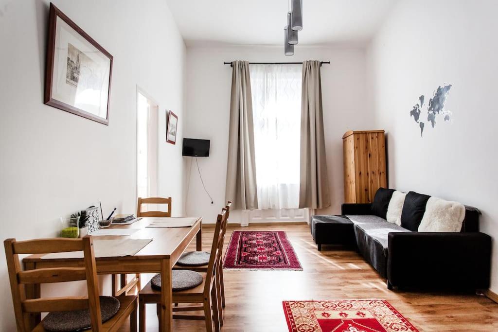 a living room with a black couch and a table at Comfortable flat with prime location near Oktogon in Budapest