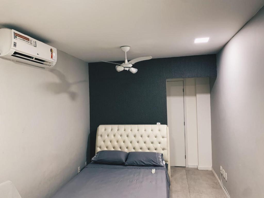 1 dormitorio con 1 cama y ventilador de techo en Apê-Loft em Frente à Praia, Recreio - RJ, en Río de Janeiro
