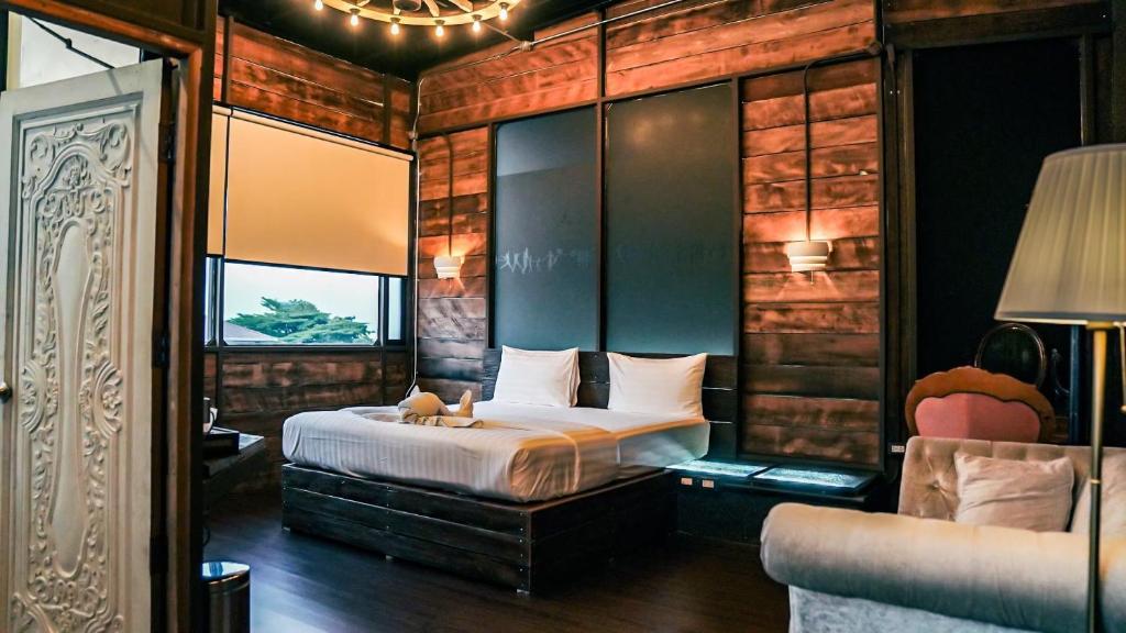 ein Schlafzimmer mit einem Bett und einem Sofa in einem Zimmer in der Unterkunft Letana Hotel in Bang Phli