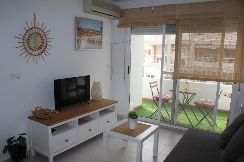 a living room with a television and a table at TBC The Beach Corner in Canet de Berenguer