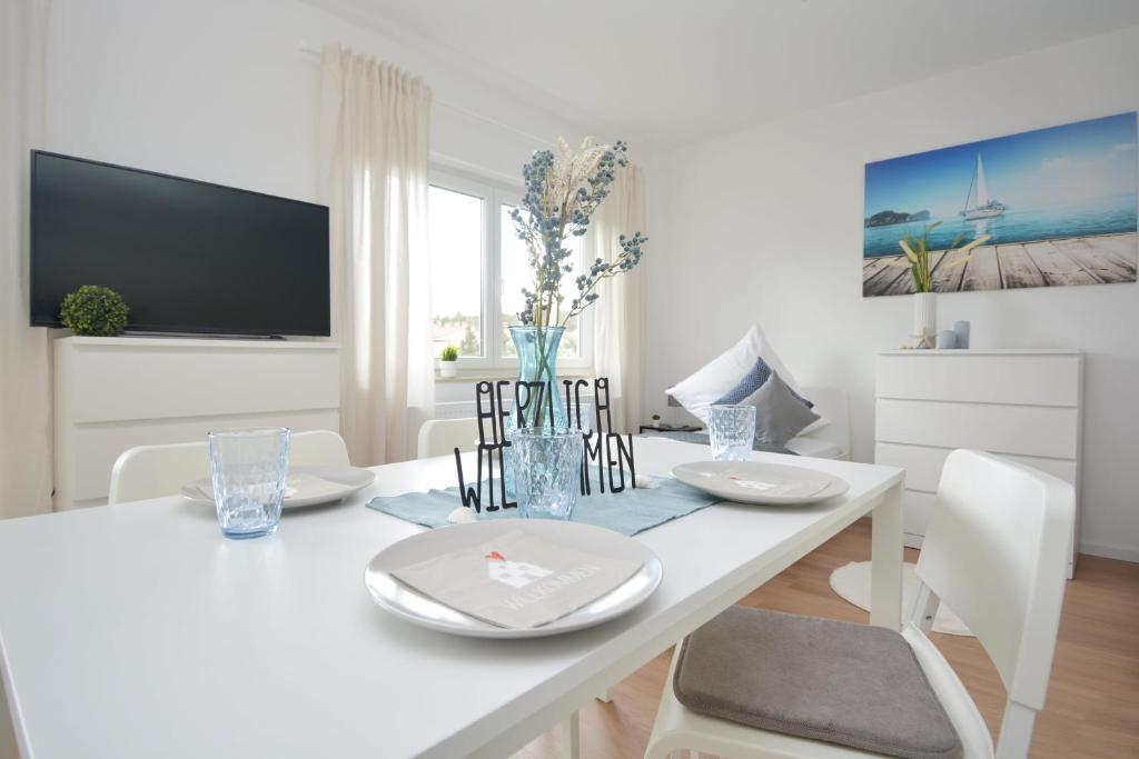 a white dining room with a white table and chairs at RT02-FW Wohnung in Schwanstetten in Schwanstetten