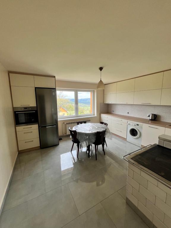 cocina con mesa y ventana grande en Willa Koniaków, en Koniaków