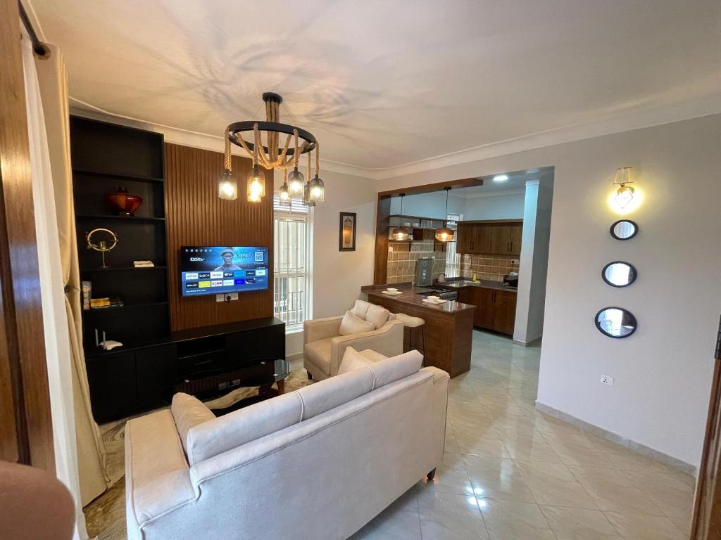 - un salon avec un canapé et une télévision dans l'établissement 8693 Abba Place, à Kampala