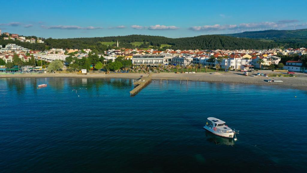 a boat in the water next to a beach at Sunsan Hotel in Canakkale