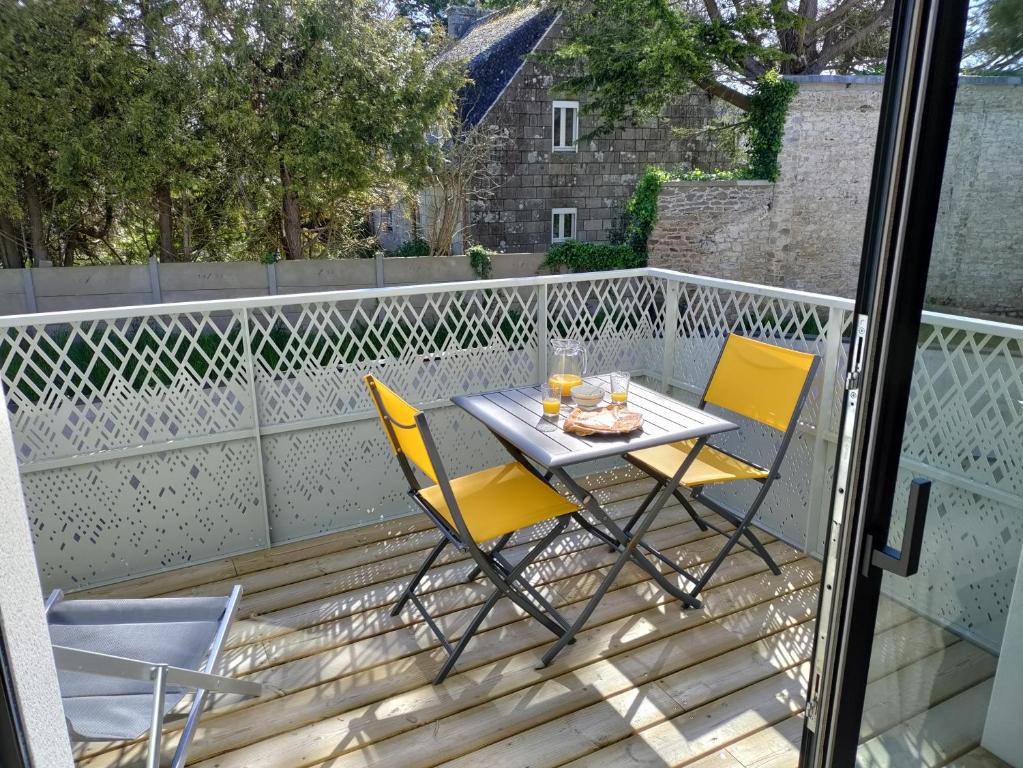 une table et des chaises assises sur un balcon dans l'établissement Évasion en bord de mer - 350m plage - Garage privé, à Concarneau