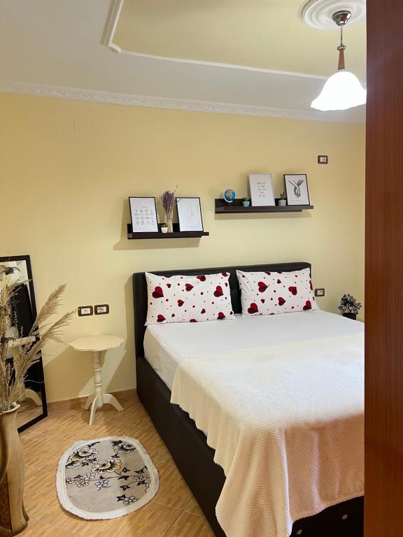 a bedroom with a bed with red and white pillows at Guest House Dimos Kristi in Përmet