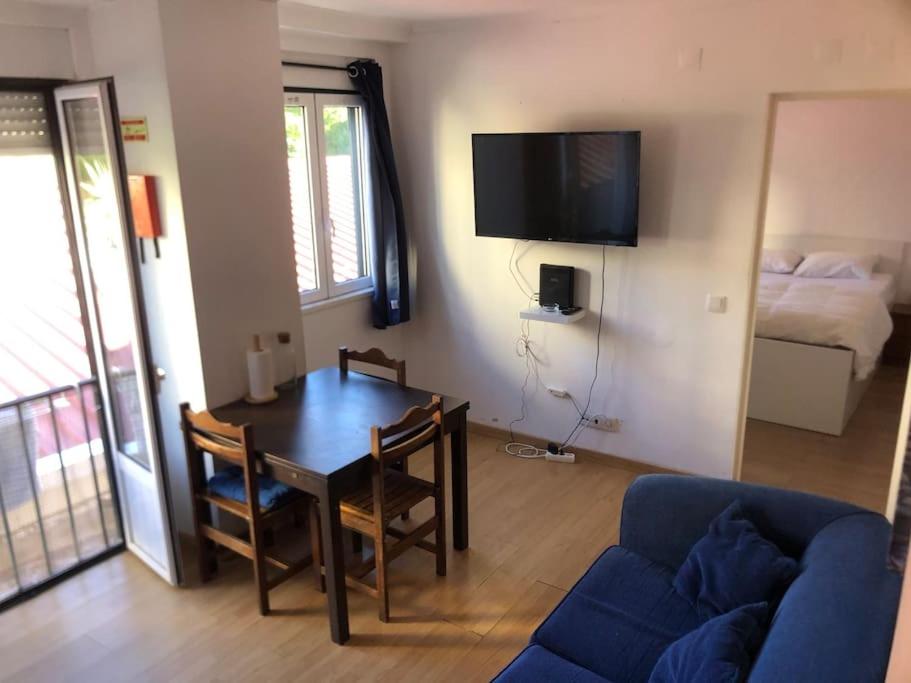 een woonkamer met een tafel en een blauwe bank bij Sunny Two Bedroom Apartment in Lissabon