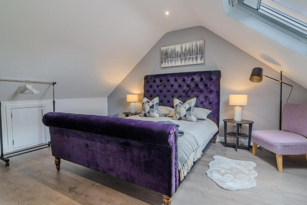 um quarto com uma cama roxa e uma cadeira em Gorgeous Loft Room em Beckenham