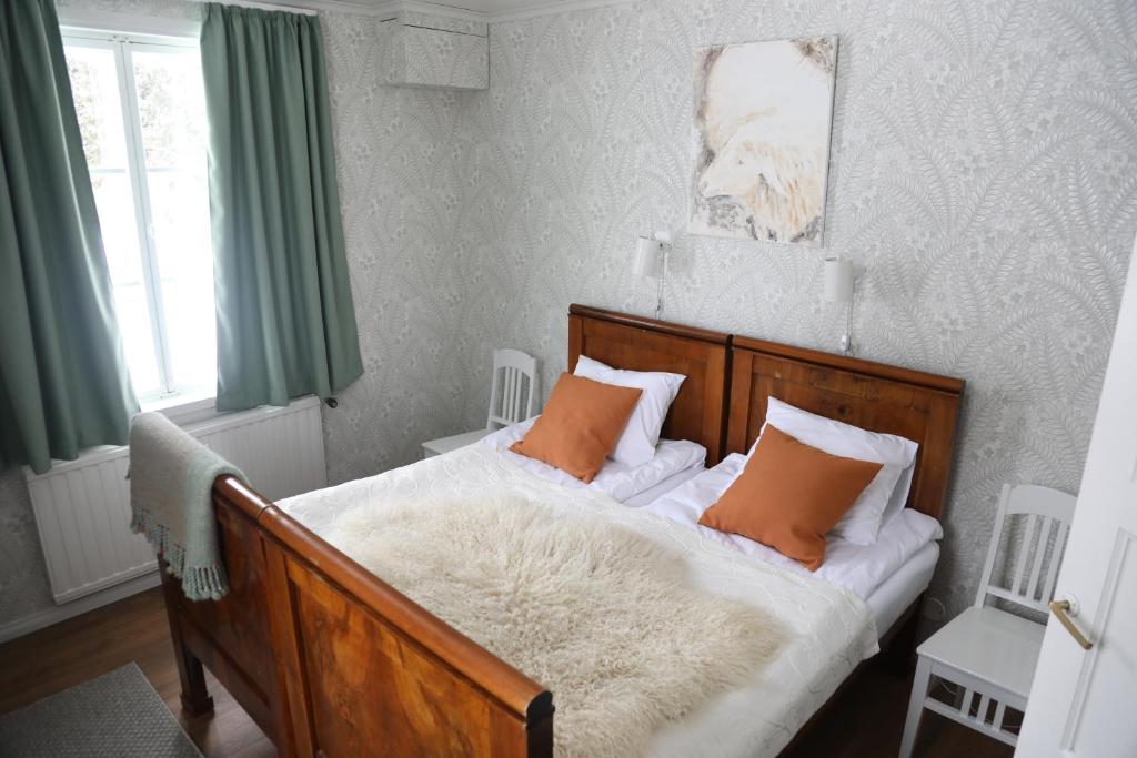 a bedroom with a wooden bed with orange pillows at Putkisalon Kartano Hellahuoneisto in Rantasalmi