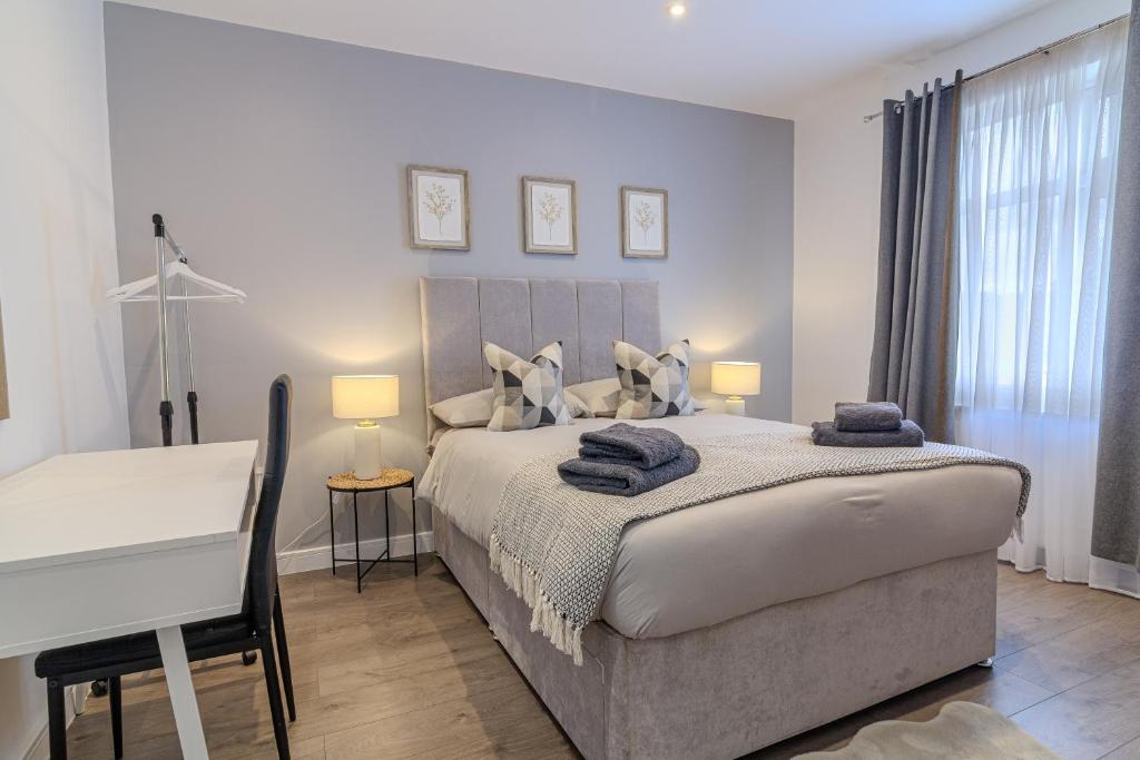 een witte slaapkamer met een groot bed en een bureau bij Exquisite Double Room in Beckenham