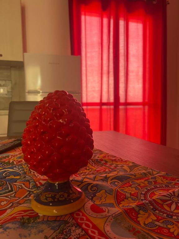 un vaso pieno di fiori rossi sopra un tavolo di Miramare a Balestrate