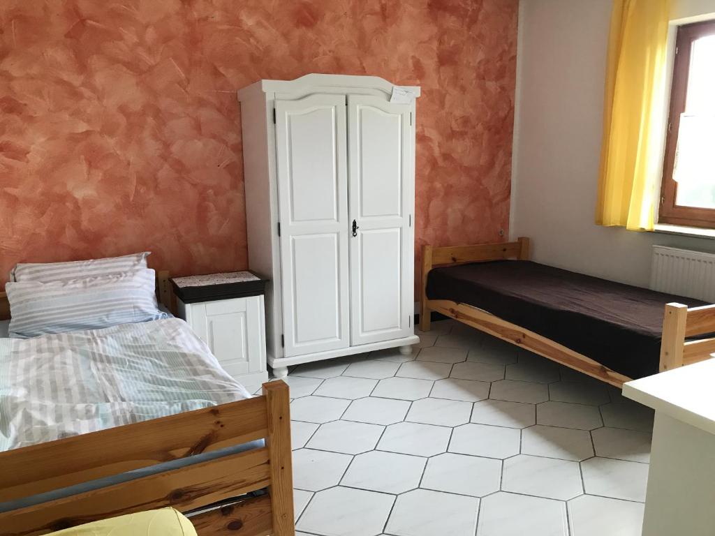 - une chambre avec 2 lits et une armoire dans l'établissement Ferienwohnung Landidylle, à Friedrichshausen