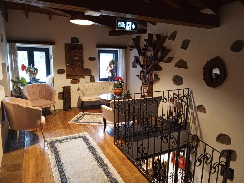 a living room with a stairway with a clock on the wall at Areto Konak Otel in Dereköy