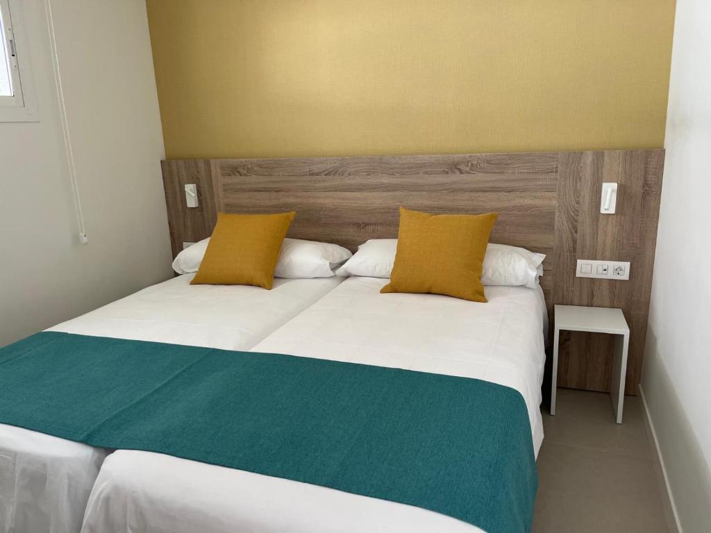 a bedroom with a large bed with yellow and green pillows at Albatros Apartments by Malibu in Callao Salvaje