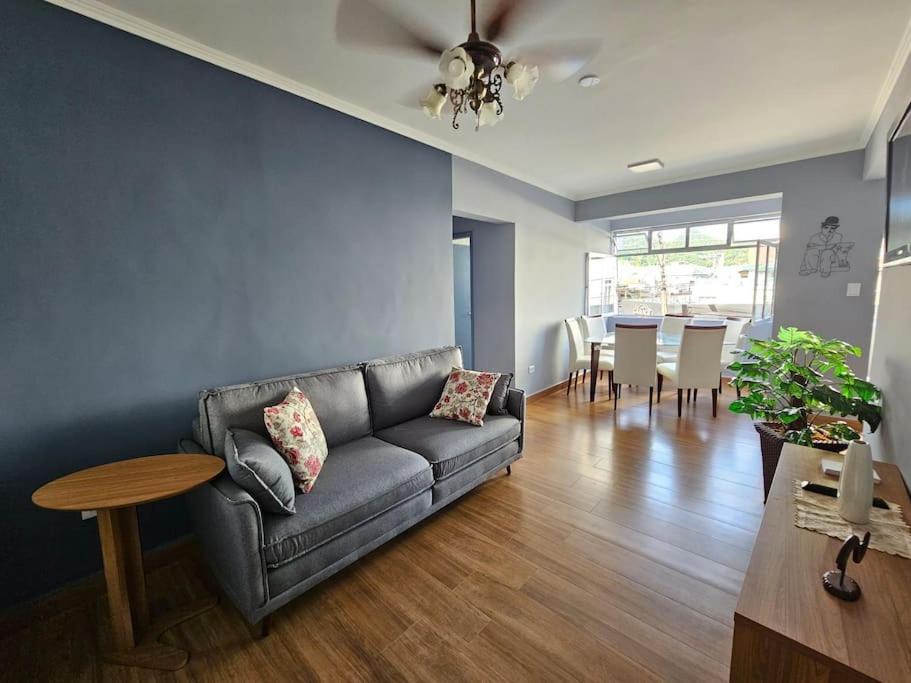 a living room with a couch and a table at Apartamento bem localizado. in Caraguatatuba