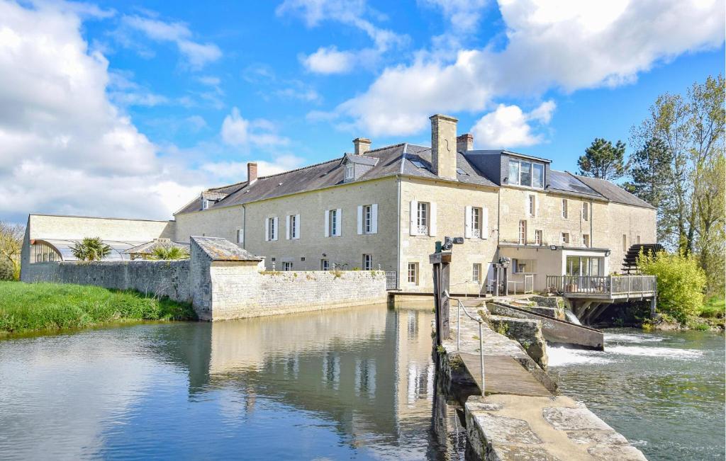 un gran edificio a orillas de un río en Gorgeous Home In Vienne-en-bessin With Private Swimming Pool, Can Be Inside Or Outside en Vienne-en-Bessin