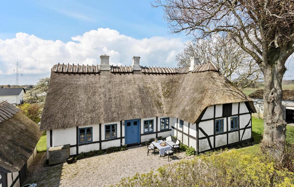 Casa con techo de paja y mesa en 4 Bedroom Beautiful Home In Tranekr, en Tranekær