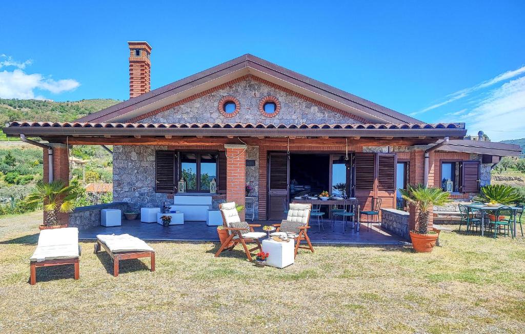 Cette maison dispose d'une terrasse avec des chaises et une table. dans l'établissement Gorgeous Home In Graniti With Wifi, à Graniti