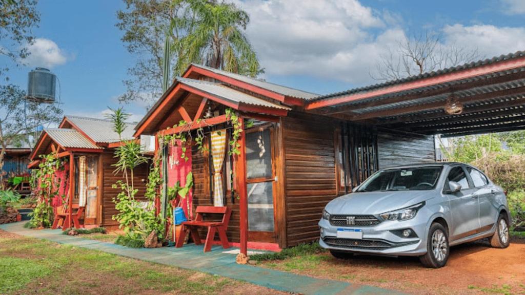 a car parked in front of a small house at Escapada Natural Bungalows El Pindó in General Alberdi