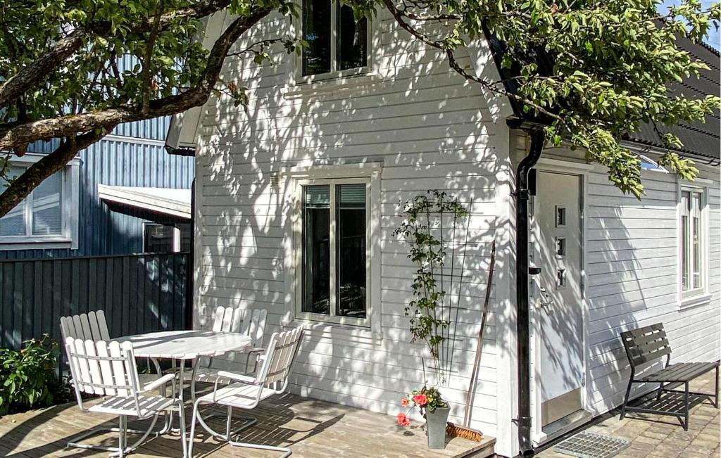 Cette maison blanche dispose d'une terrasse avec une table et des chaises. dans l'établissement Beautiful Home In Alingss With Wifi, à Alingsås