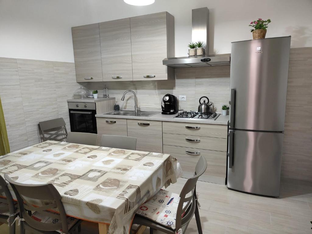 een keuken met een tafel en een roestvrijstalen koelkast bij Holiday house Chiara in Giardini Naxos