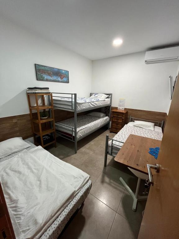 a room with two beds and a table and a desk at Cozy room next to el prat airport in El Prat de Llobregat