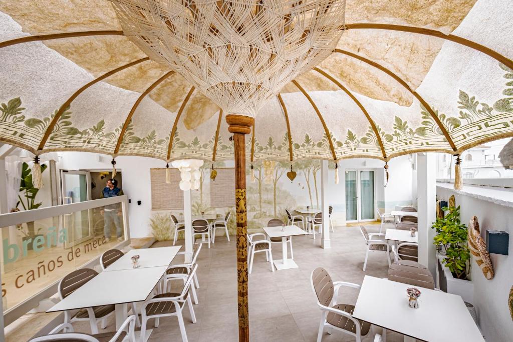 un restaurante con un gran techo con mesas y sillas en Escondite de Noah Grupo labreña, en Los Caños de Meca