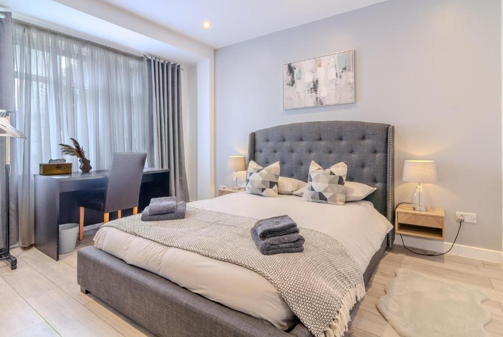 a bedroom with a large bed and a desk at Elegant Large Room in Beckenham