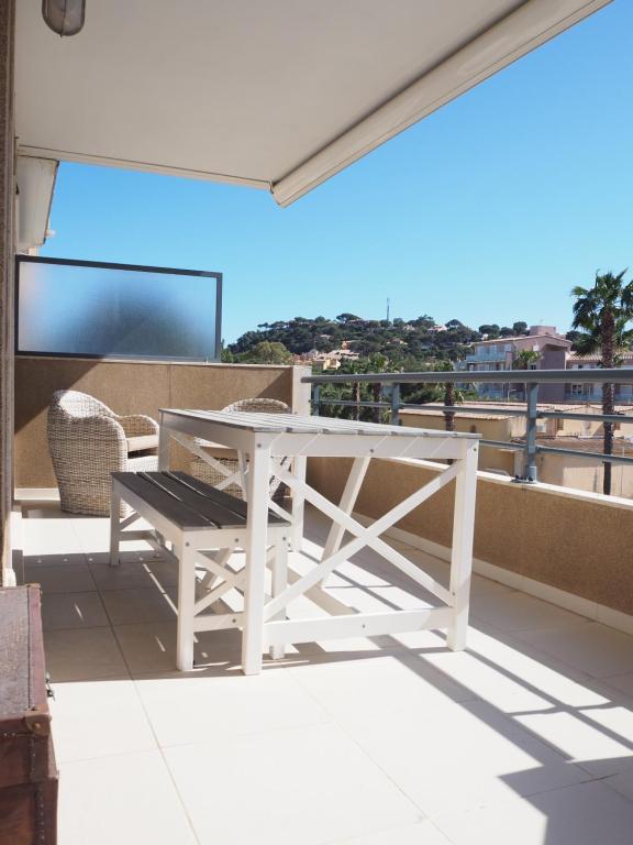 d'une table et d'un banc blancs sur un balcon. dans l'établissement Colore di mar, à Cavalaire-sur-Mer