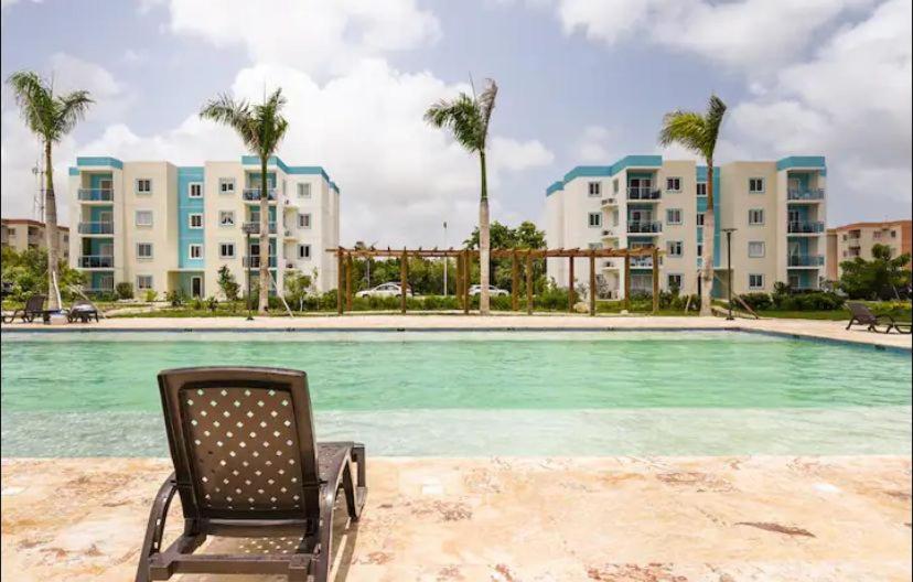 a chair sitting in front of a swimming pool at Vip Village Service in Punta Cana